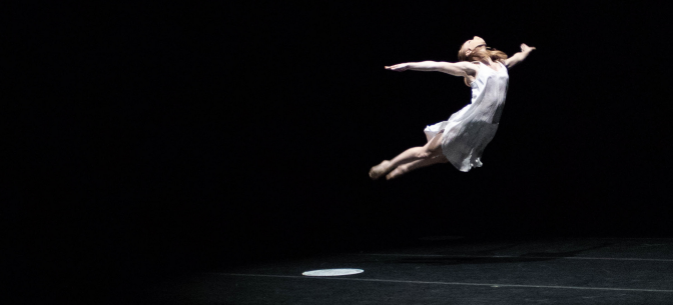 dancer appears to be suspended in midair on stage
